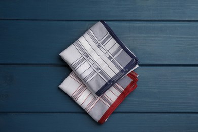 Stylish handkerchiefs on blue wooden table, flat lay