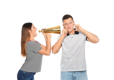 Young woman with megaphone shouting at man on white background