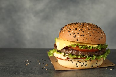 Photo of Burger with delicious patty on gray table, space for text