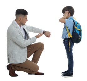 Photo of Teacher pointing on wrist watch while scolding pupil for being late against white background