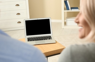 Couple using video chat on laptop at home, closeup. Space for text