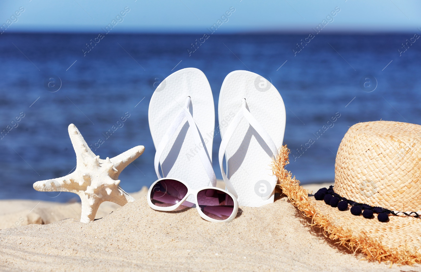 Photo of Composition with beach accessories on sand near sea in summer