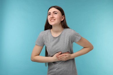 Photo of Woman having heart attack on light blue background