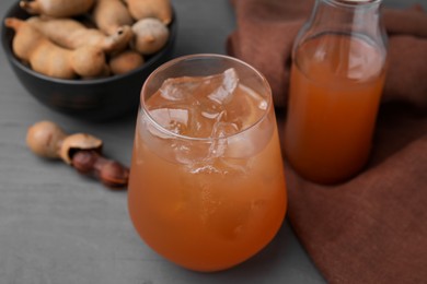 Photo of Freshly made tamarind juice on grey wooden table, closeup
