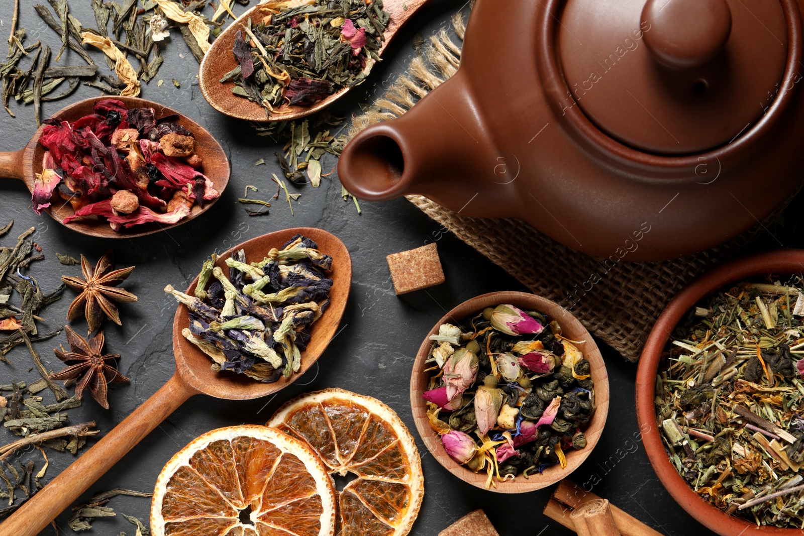 Photo of Flat lay composition with different dry teas on grey table