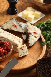 Photo of Tasty butter, dill, chili pepper and rye bread on table