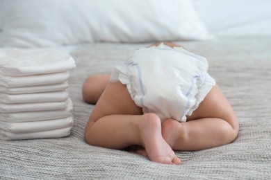 Photo of Cute little baby in diaper on bed