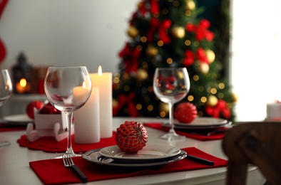 Photo of Festive table setting and Christmas tree in stylish room interior