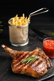 Tasty grilled beef steak on black wooden table