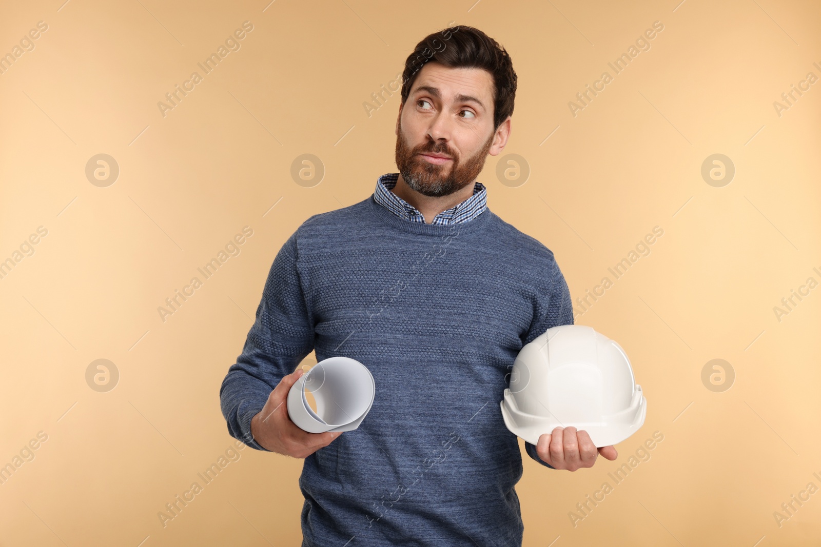 Photo of Architect with hard hat and draft on beige background