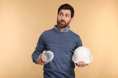 Photo of Architect with hard hat and draft on beige background