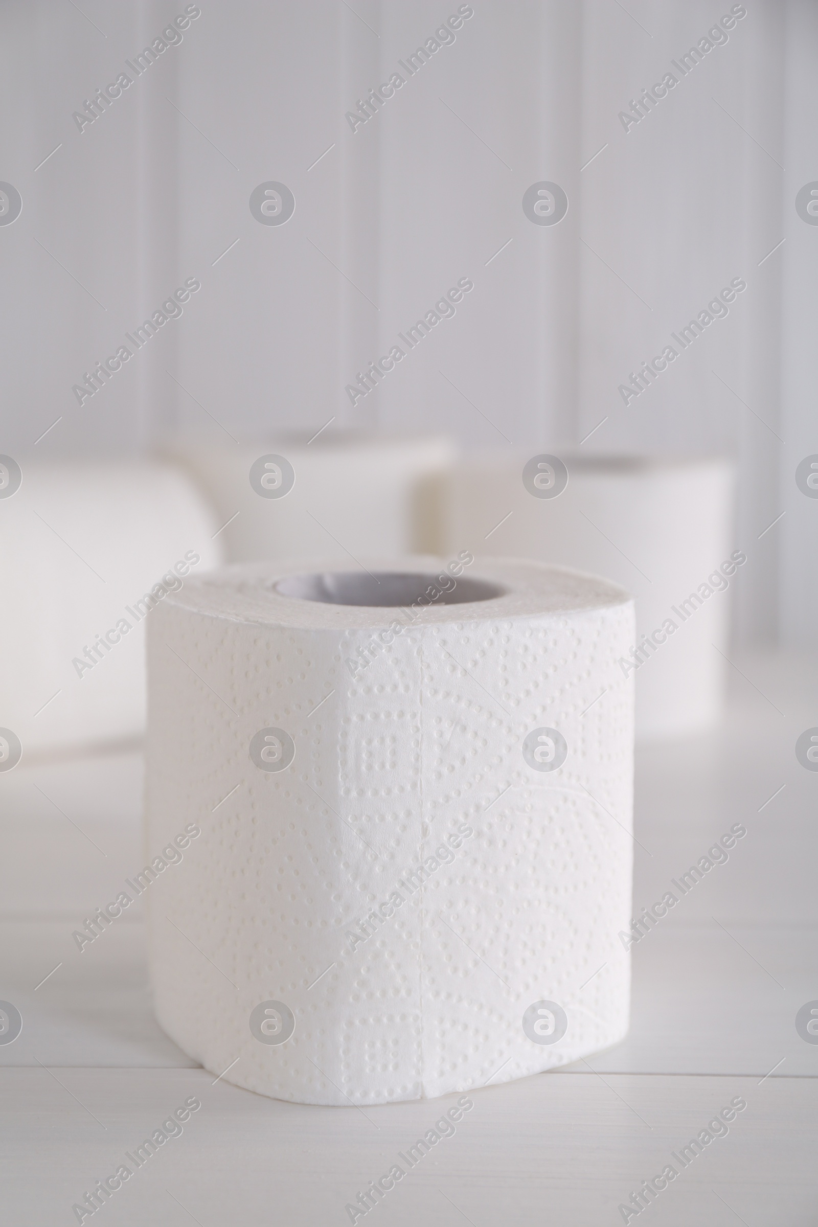 Photo of Soft toilet paper rolls on white wooden table