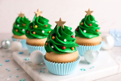 Christmas tree shaped cupcakes and decor on table