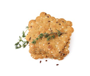 Stack of cereal crackers with flax, sesame seeds and thyme isolated on white, above view