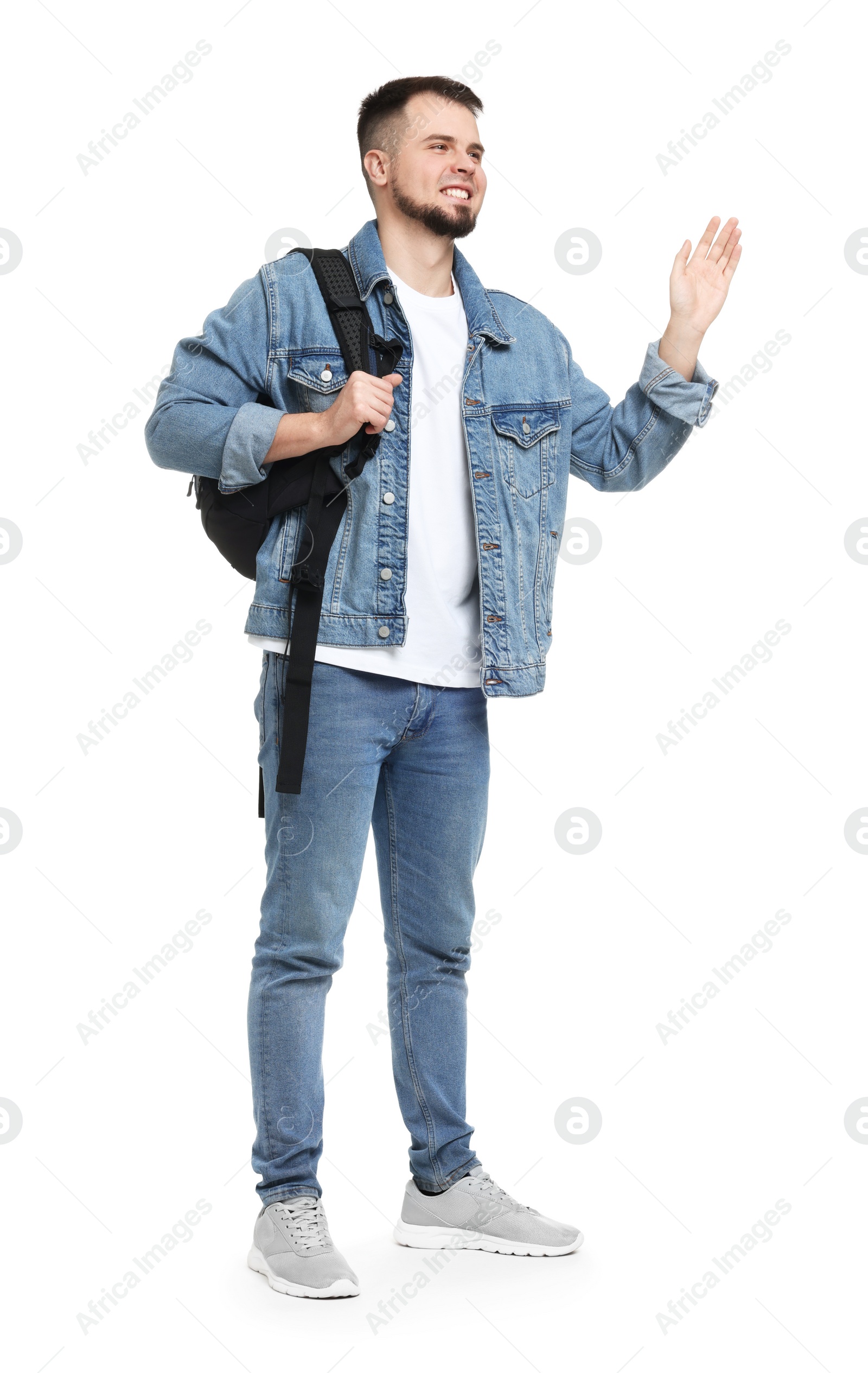 Photo of Man with backpack in denim clothes waving hand on white background