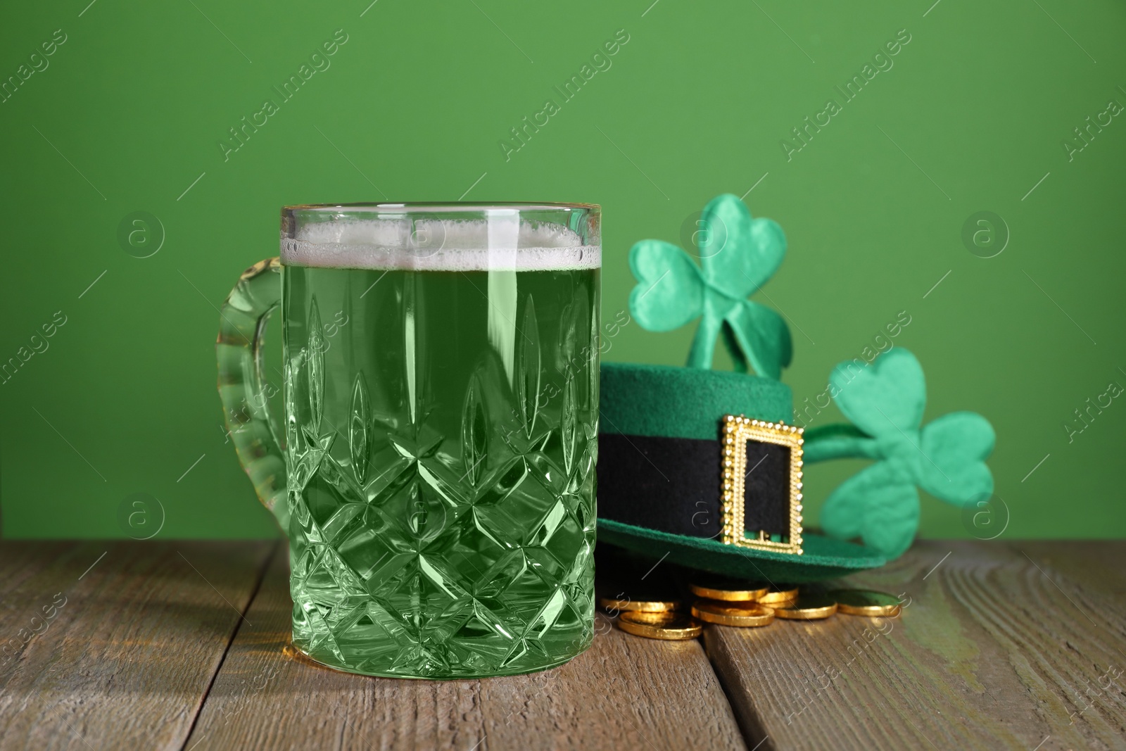 Photo of St. Patrick's day party. Green beer, leprechaun hat, gold and decorative clover leaves on wooden table