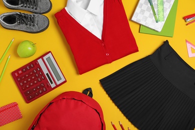 Photo of Flat lay composition with school uniform on yellow background