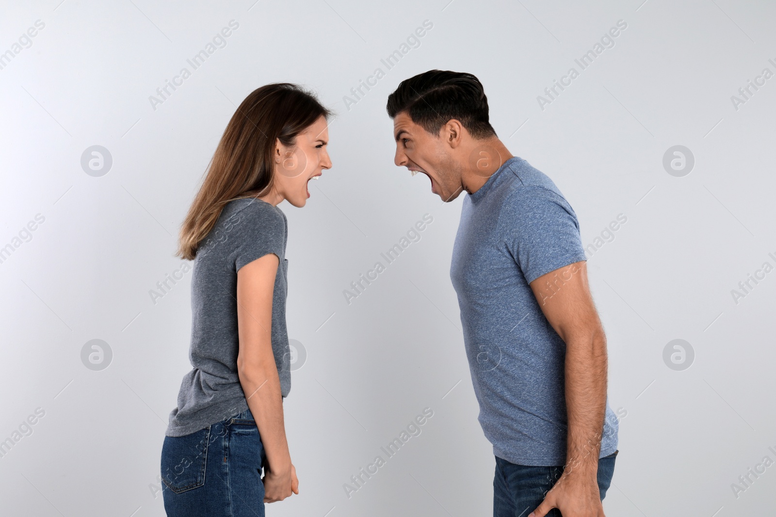 Photo of Couple quarreling on light background. Relationship problems