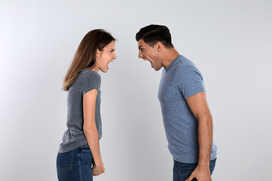 Photo of Couple quarreling on light background. Relationship problems