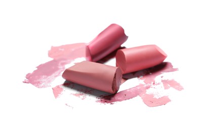 Different lipsticks and smears on white background