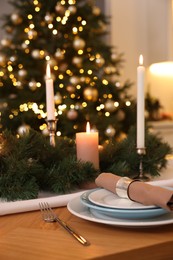 Luxury place setting with beautiful festive decor for Christmas dinner on wooden table