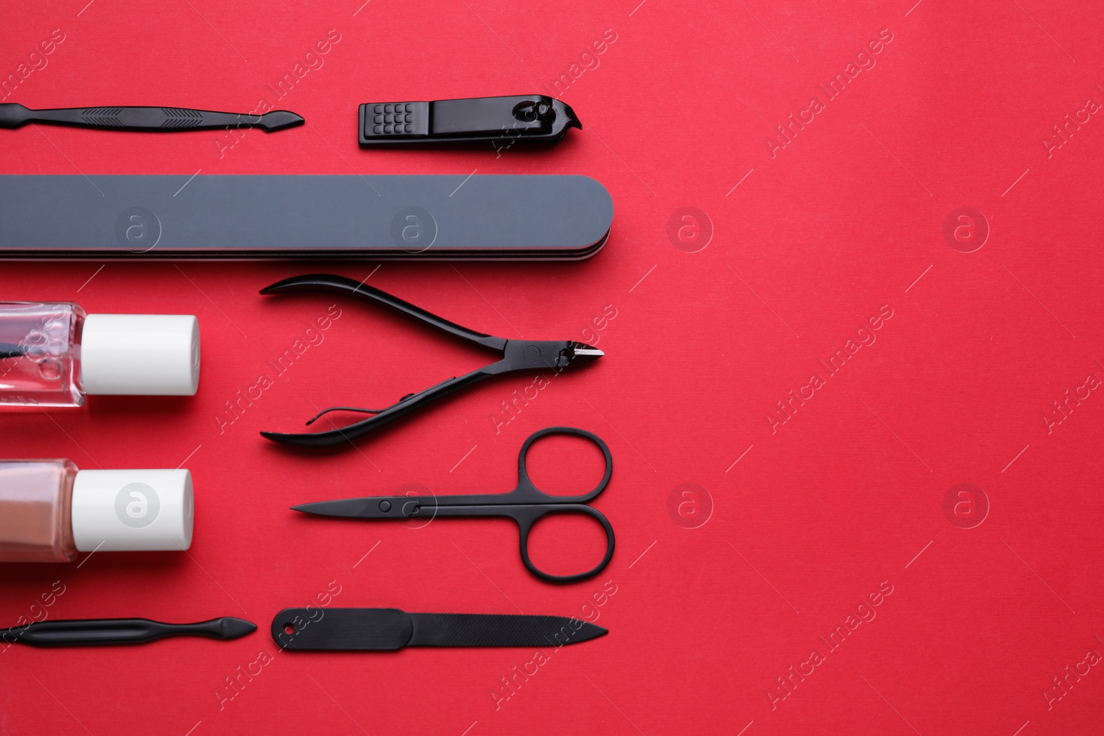 Photo of Set of pedicure tools on red background, flat lay. Space for text