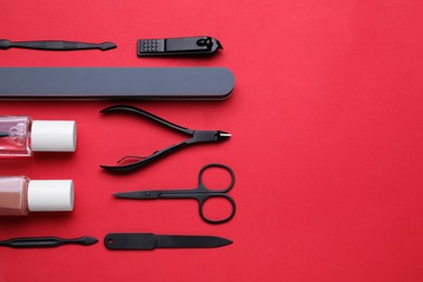 Set of pedicure tools on red background, flat lay. Space for text