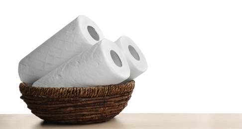 Photo of Rolls of paper tissues in basket on wooden table