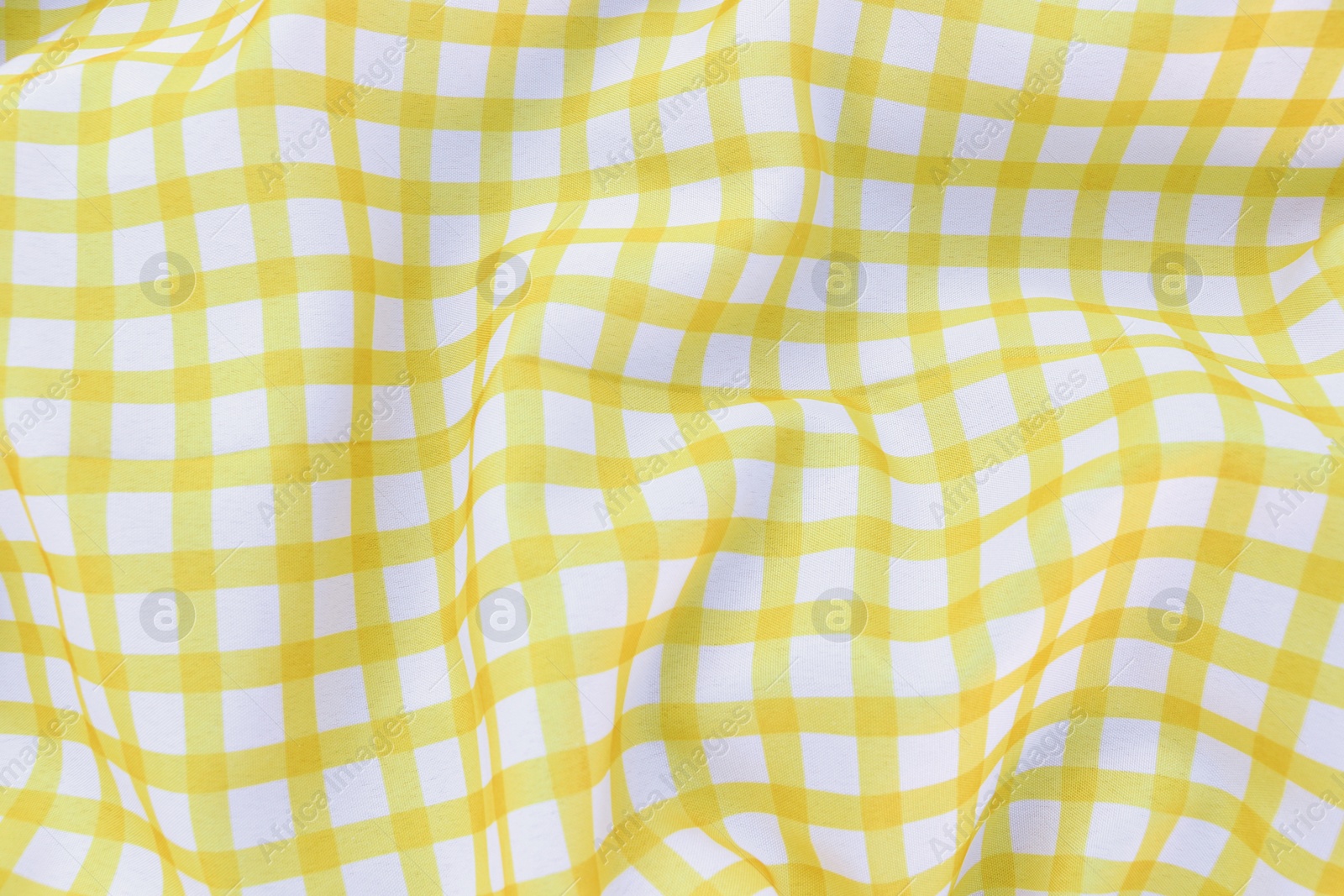 Photo of Yellow checkered picnic tablecloth as background, top view