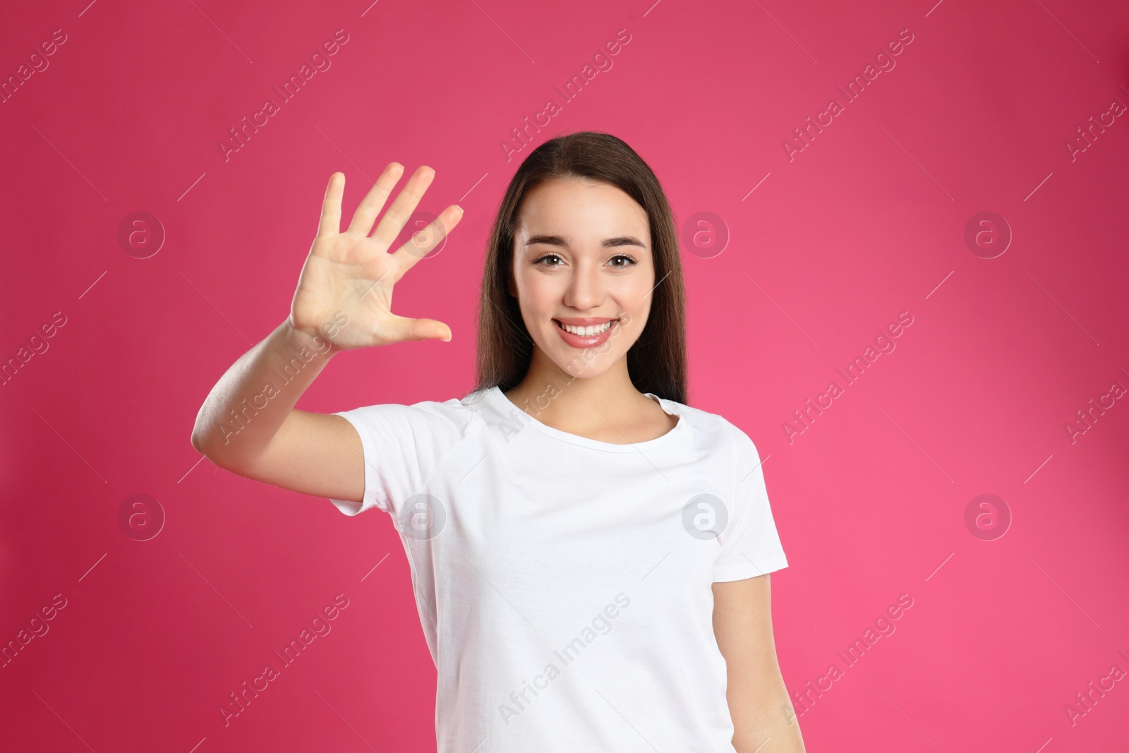 Photo of Woman showing number five with her hand on pink background