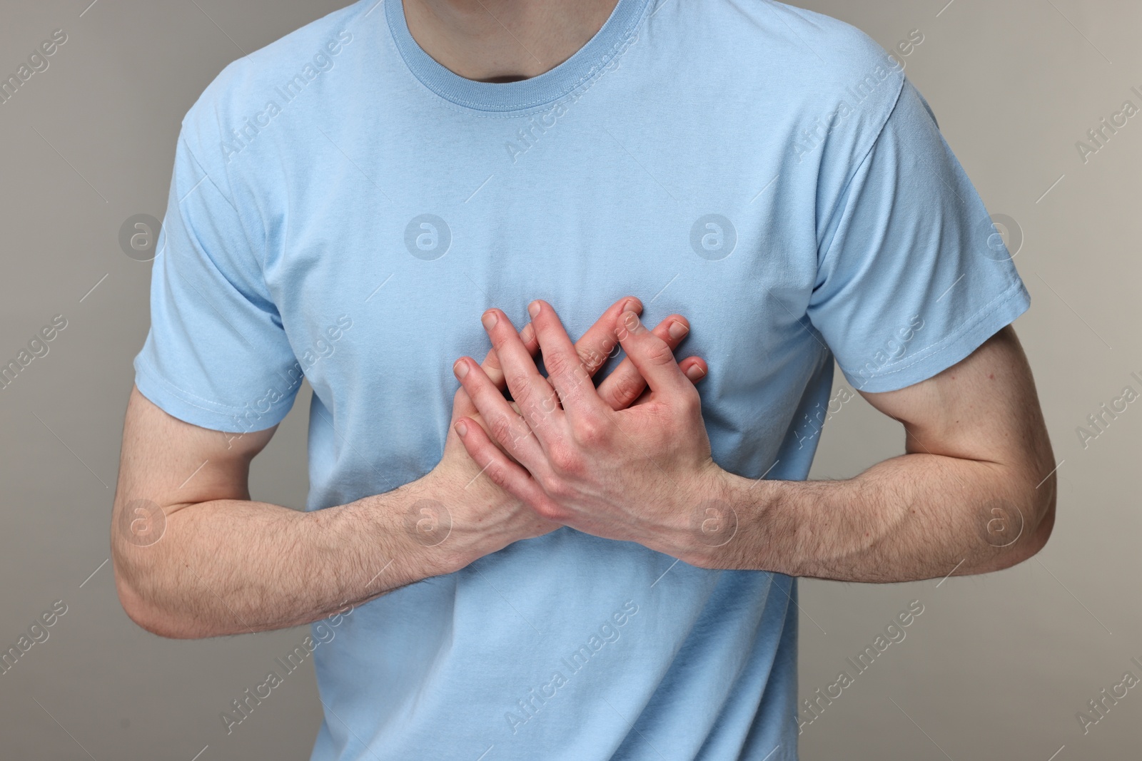 Photo of Man suffering from heart hurt on grey background, closeup