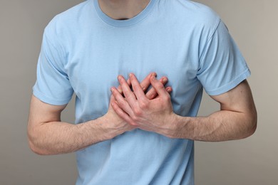 Photo of Man suffering from heart hurt on grey background, closeup