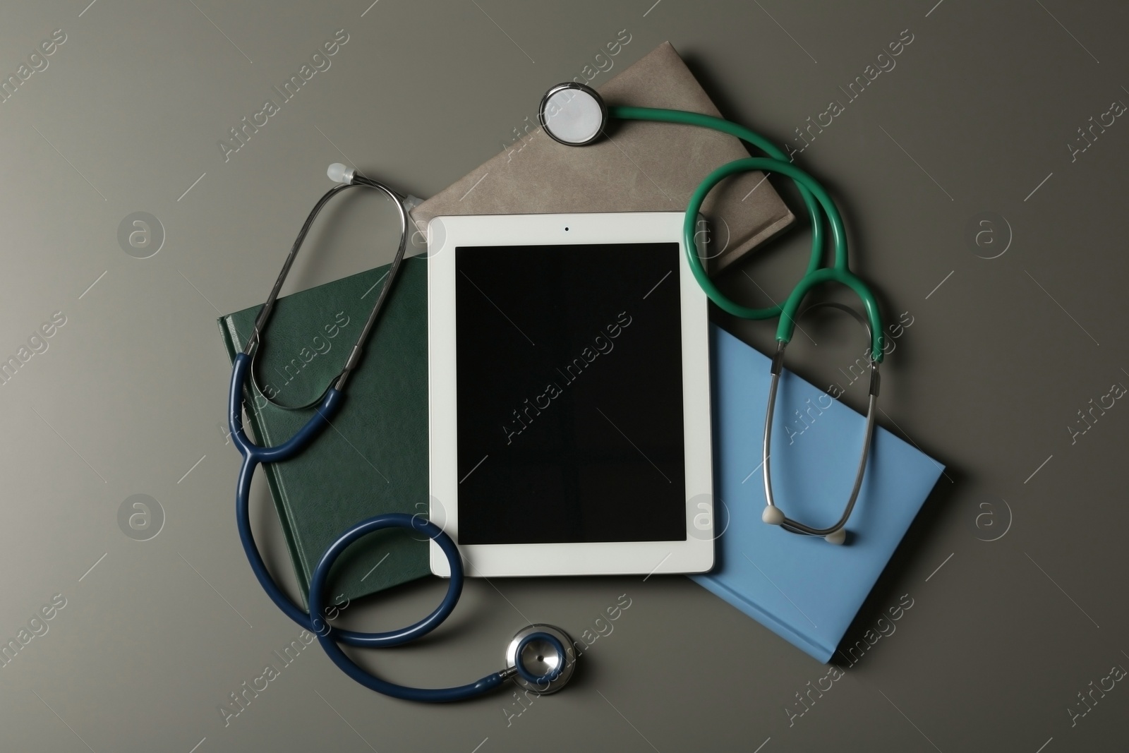 Photo of Flat lay composition with stethoscopes and tablet on table, space for text. Medical students stuff