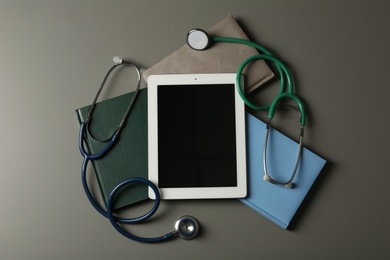 Flat lay composition with stethoscopes and tablet on table, space for text. Medical students stuff