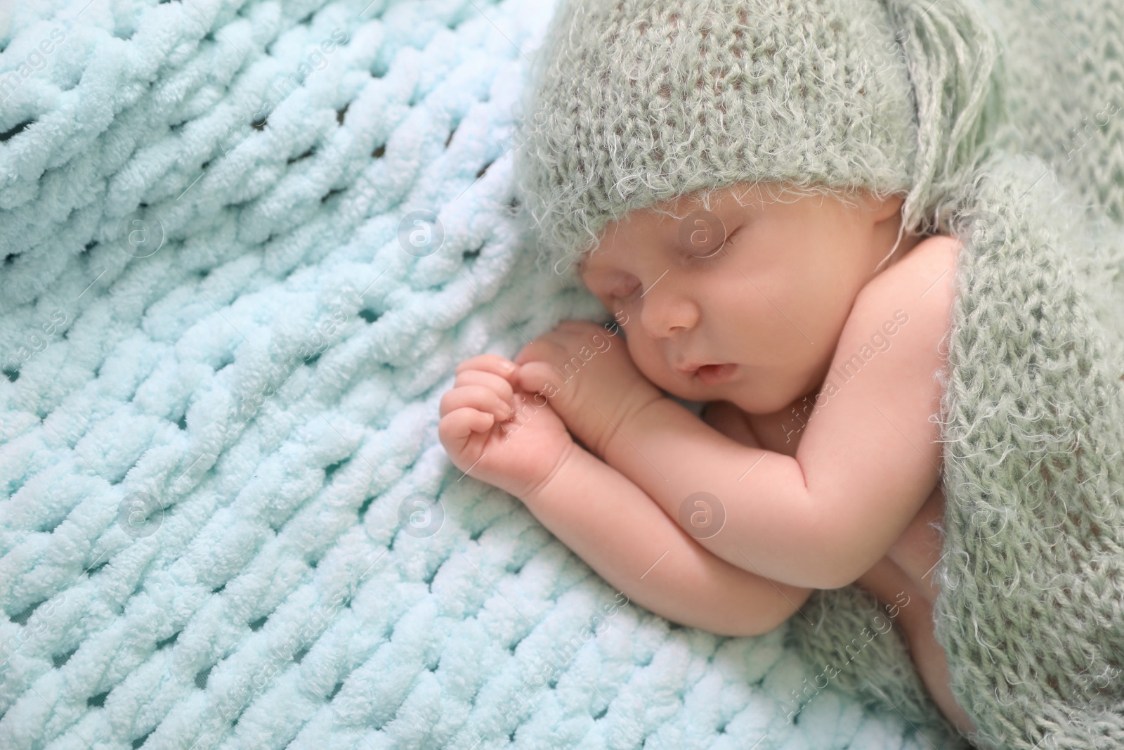 Photo of Cute newborn baby sleeping on light blue blanket, top view. Space for text