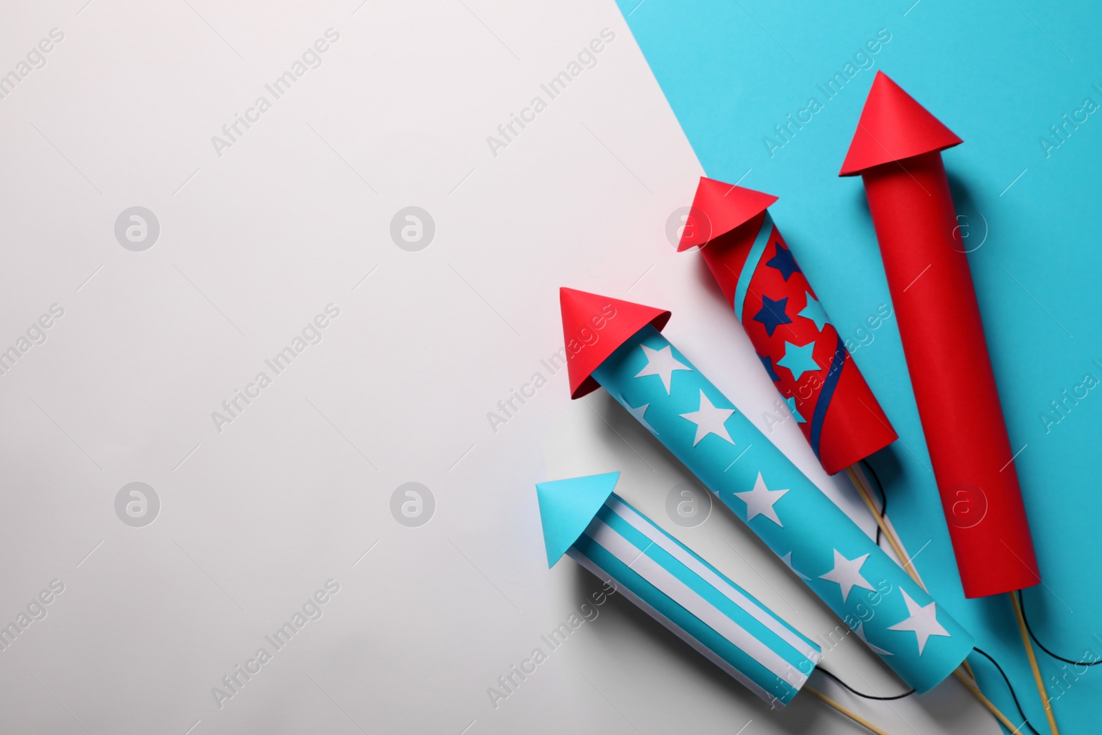 Photo of Firework rockets on color background, flat lay with space for text. Festive decor