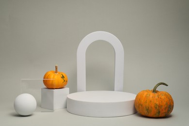 Photo of Autumn presentation for product. Geometric figures and pumpkins on light grey background