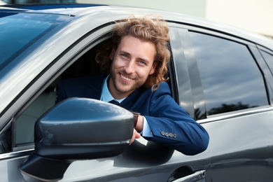 Photo of Attractive young man in his luxury car