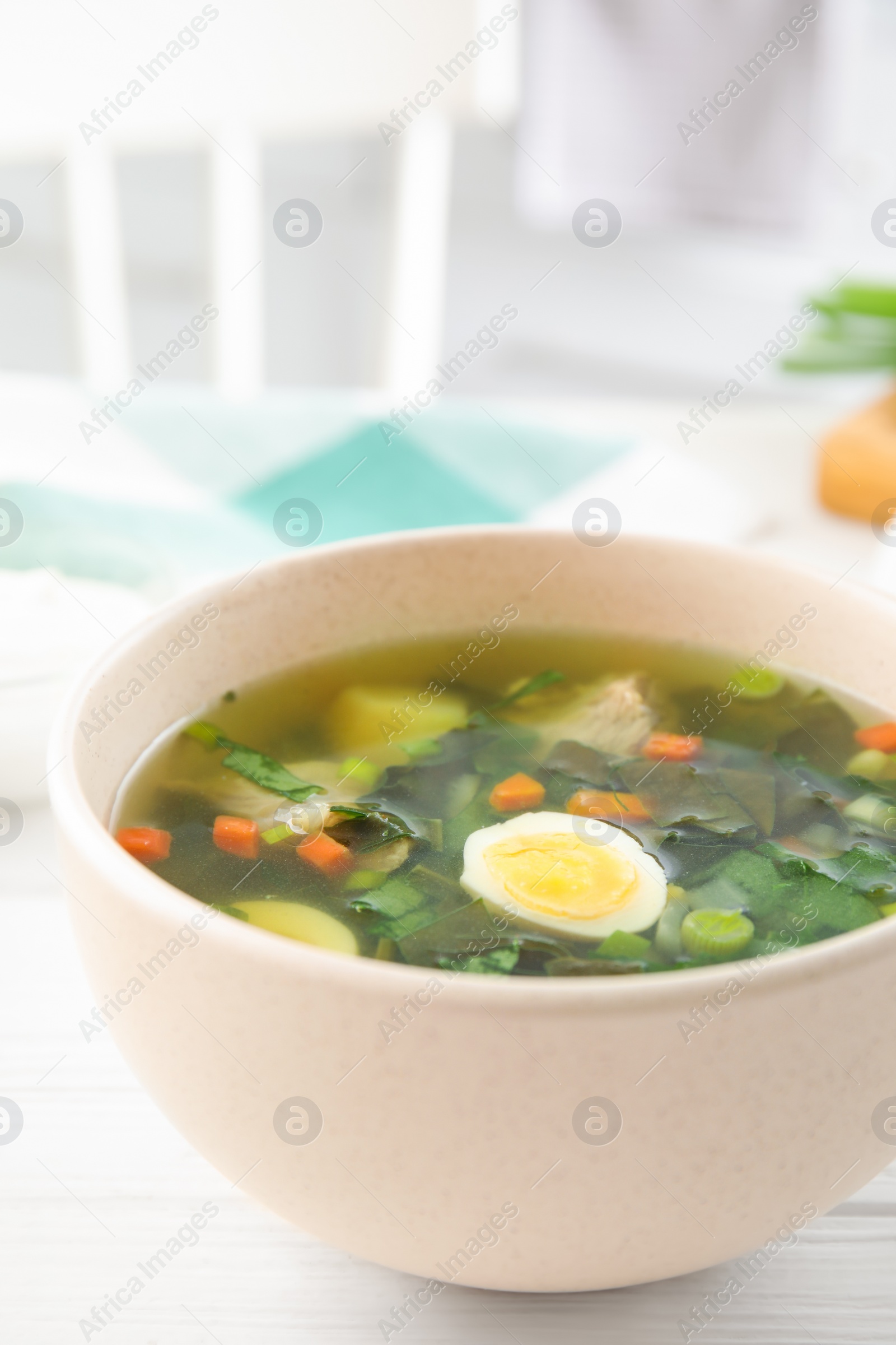 Photo of Delicious sorrel soup with meat and egg served on white wooden table