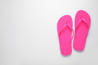 Stylish pink flip flops on white background, top view. Space for text