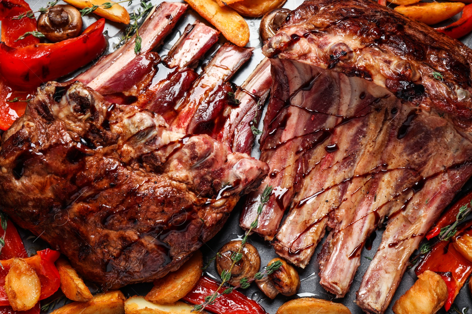 Photo of Delicious roasted ribs with garnish, flat lay