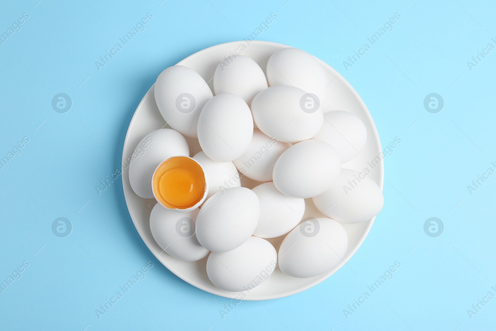 Photo of Fresh raw chicken eggs on light blue background, top view