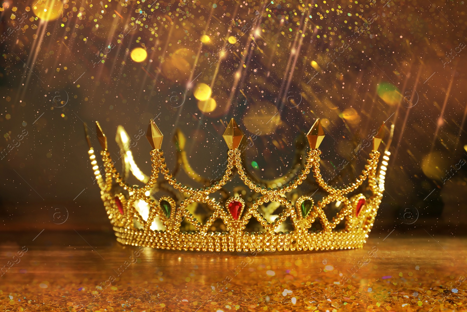 Image of Fantasy world. Beautiful golden crown on table, bokeh effect