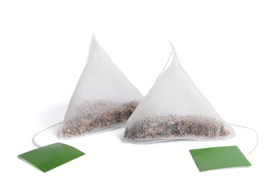 Photo of Paper tea bags with tags on white background