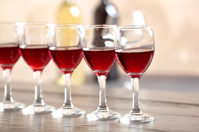 Glasses with delicious red wine on table