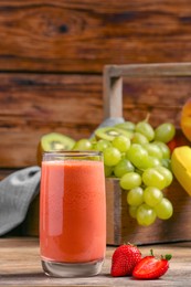 Glass with tasty smoothie on wooden table