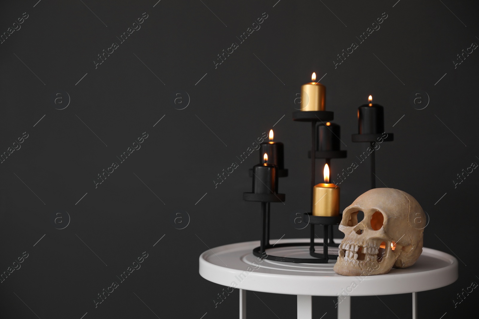 Photo of Halloween decor on table near black wall, space for text. Idea for festive interior