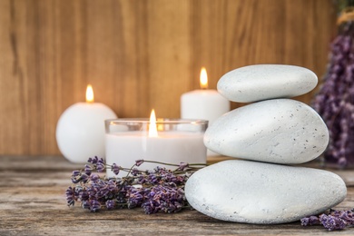 Photo of Spa stones with lavender flowers and candles on table