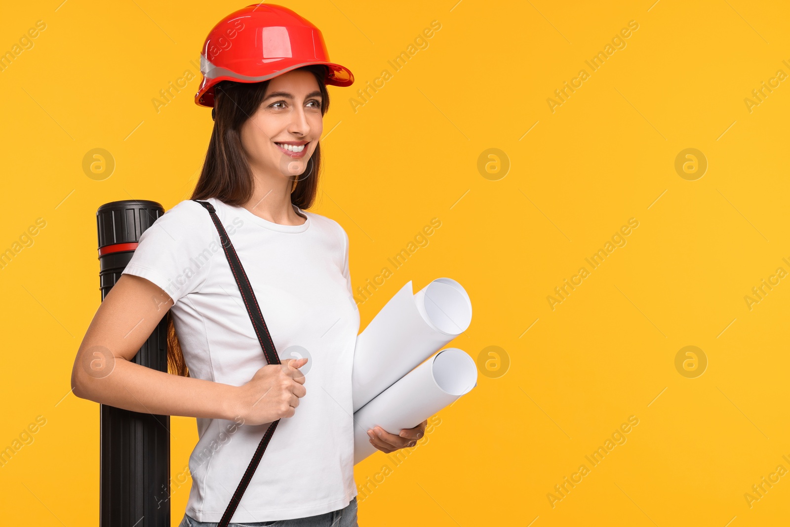 Photo of Architect in hard hat with drafts and tube on yellow background, space for text