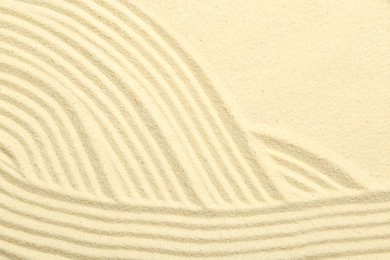 Photo of Zen rock garden. Wave pattern on beige sand, top view